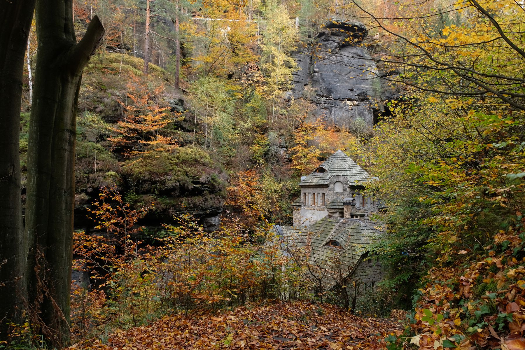 Old building beneath rock formation