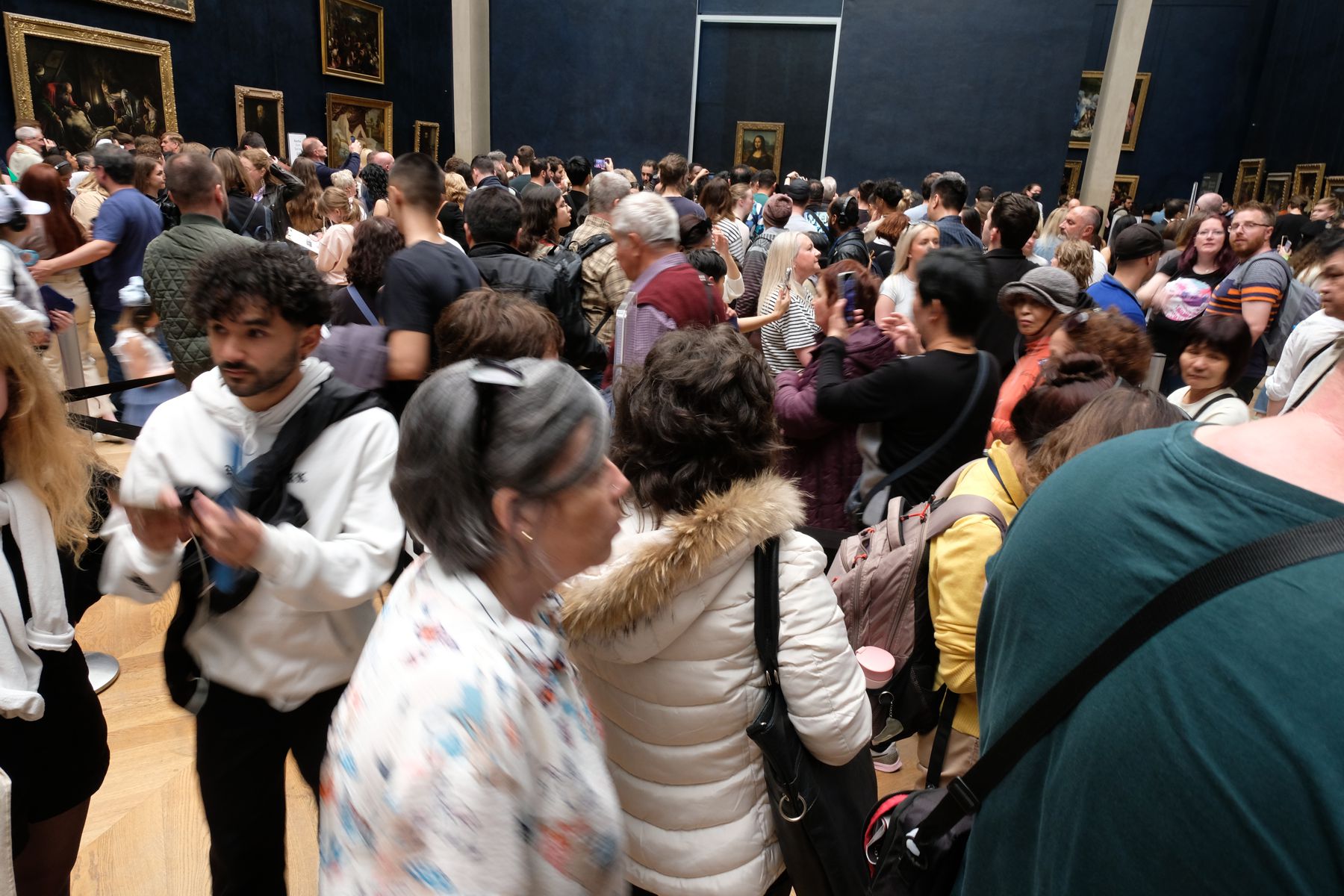 Crowd trying to get close enough to Mona Lisa for a selfie.